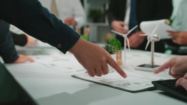 Bir grup iş adamı modern bir ofiste ortak bir toplantı yapıyorlar. Belgeler ve dijital cihazlarla etkileşim halindeyken stratejileri tartışıyorlar. SACTR