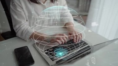 Küresel bağlantı ve teknoloji gelişimini sembolize eden, dijital dünya arayüzü ile çevrili, dizüstü bilgisayarda yazı yazan bir kadının yer aldığı modern bir çalışma alanı. Xenic