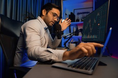 Akıllı tüccar işadamı, karanlık oda gecesinde neon ışıklı ofisteki arama pazarında yüksek kârla ekranda bilgisayar ve bilgisayar üzerinde dinamik borsa yatırımları üzerinde yoğunlaşıyor. Tahmin et..