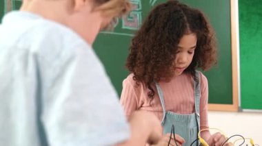 Dizüstü bilgisayar ekranında çalışan çeşitli öğrenci kodlama mühendisliği komut yazılımı ve yapay zeka programlaması yapıyor. Amerikalı kız, erkek makine tamir ederken ekipmanları teftiş ediyor. Pedagoji.