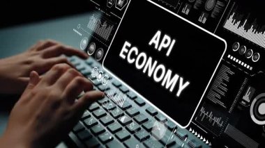 API Ekonomi Konsepti ve Veri Görselleştirmeleri 'ni gösteren Dijital Arayüz ile Klavyede Yazan Eller. Asemptotik akıllı veri analitiği.