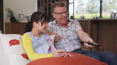 Büyükbaba ve torun birlikte TV 'de ilginç bir eğlence medyası izliyorlar. Eski üst düzey kullanım teknolojisi, genç nesil çapraz nesil ile iletişim kurarak aile bağlarını güçlendiriyor. Uyumsuzluk.