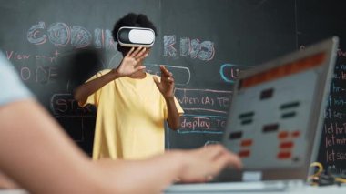 VR kullanan Afrikalı öğrenci meta-dünya ile etkileşime girerken liseli kız el kodlama programını kapat. Zeki çocuk sanal gerçeklik gözlüğü takıyor ve yenilikçi sınıfta video oyunları oynuyor. Öğretim
