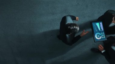 Profesyonel iş adamının yukarıdan görünüşü bir ekibe katıldı ve yönetici müdürle tokalaştı. Akıllı pazarlama ekibi tabletteki yatırım verilerini analiz etmek için birlikte çalışıyor. Müdürlük.