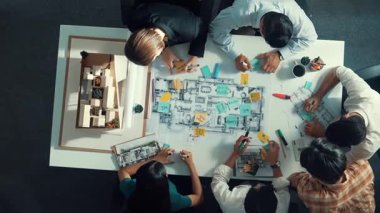 Proje yöneticisi ya da inşaat mühendisinin planlama ve planlama binasında yazışmalarının üst düzey görüntüsü. Toplantı masasında birlikte çalışan mimarın belgeyle birlikte havadan görünüşü. Hizalama.