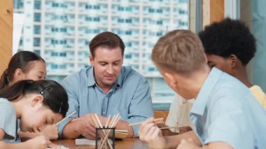 Sıradan tişörtlü zeki liseli çocuk, karışık ırkları olan öğrenciler kitap yazarken profesyonel öğretmene soruyor. Yaratıcı çocuk notayı işaret ederken Kafkas eğitmeni yorum yapıyor. Öğretim