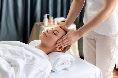 Kafkasyalı kadın stres önleyici kafa masajından ve lüks tatil beldesi ya da otel spa salonundaki modern ışık ortamında yüz güzelliği eğlencelerini şımartmaktan hoşlanıyor. Sessiz.