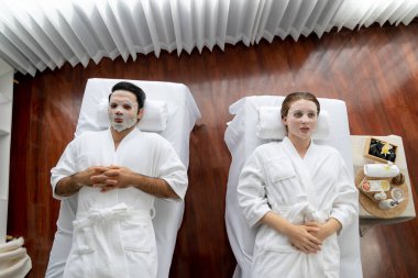 Kaplıca salonunun sakin, modern gündüz atmosferi, birkaç müşteri yüz maskesi takarak kendini yenilemeye çalışıyor. Yüz bakımı ve güzellik kozmetolojisi prosedürü. Sessiz.