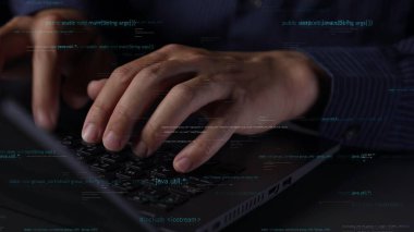 Bu resim, dijital kodlarla çevrili bir dizüstü bilgisayarın klavyesinde yazılan ellerin yakın çekim görüntüsünü, çağdaş bir çalışma alanında teknolojiyi ve programlamayı somutlaştırır. Xenic