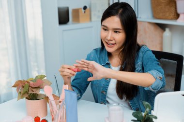 Genç, güzel Asyalı kozmetik makyaj ruju matte pastel rengini modern odadaki sosyal medyada kol testi tanıtımında en çok satanlar listesinde gösteriyor. Taktik.