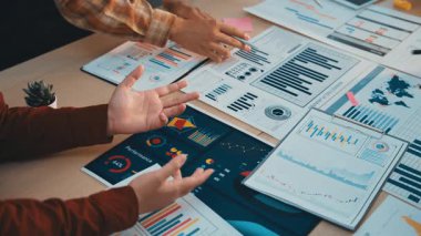 İş ortamında takım çalışması ve stratejik planlamayı vurgulayarak çeşitli analitik çizelgeler ve raporlar üzerinde işbirliği yaptığını gösteren profesyonel bir ortam. SACTR