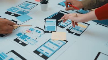 Eller, akıllı telefonlar ve yaratıcılığı ve takım çalışmasını gösteren tasarım araçlarıyla dolu bir çalışma alanı üzerinde kullanıcı arayüzü kavramları çizerek mobil uygulama tasarım oturumuna katıldı. SACTR