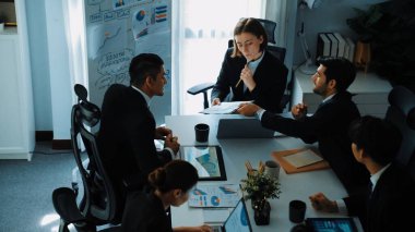 Akıllı yönetici projesinin üst görünümü beyaz tahtaya zihin haritası ve finansal grafik ile işaret ediyor ve çeşitli yatırımcılar hisse yatırım grafiğini dinleyip analiz ederken pazarlama fikrini açıklıyor. Müdürlük.