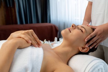 Kafkasyalı kadın stres önleyici kafa masajından ve lüks tatil beldesi ya da otel spa salonundaki modern ışık ortamında yüz güzelliği eğlencelerini şımartmaktan hoşlanıyor. Sessiz.