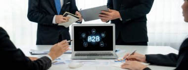 İş adamı B2B peyzajında geziniyor, iş-iş bağlantılarını geliştirmek için kullanım teknolojisi kullanıyor. B2B etkileşimini yeniden şekillendiren keşifler, iş-iş stratejilerinde yenilikleri yönlendiren araçlar. canlı