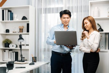 Gülümseyen Asyalı iş arkadaşları modern ofiste dizüstü bilgisayar pazarlama projesi hakkında konuşurken. Yeni sosyal medya kanalında başarılı müşteri ihtiyaçları analiz ediliyor. İnfobahn.