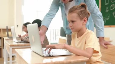 Çeşitli öğrenciler yapay zeka yazılımı kullanırken, Kafkas öğretmeni enerjik çocuğa kodlama konusunda yardım ediyor. Çocuklar oturma ve programlama sistemi. Sevimli bir öğrenci şifreyi öğreniyor. Pedagoji.