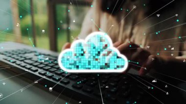 Ofis ortamında modern teknoloji ve bağlantıyı temsil eden çeşitli dijital sembollerle çevrili canlı bir bulut simgesiyle klavyeye yazı yazan bir kişi. Xenic
