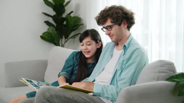 Beyaz bir baba ve tatlı bir kız kanepede otururken masal kitabı okuyorlar. Mutlu bir baba, sevimli bir Amerikan çocuğuna, birlikte zaman geçirirken hayal gücünün gelişmesi için hikaye anlatıyor. Pedagoji.