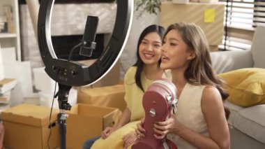 İnternette yayınlanırken gitar kılıfını gösteren ve satan mutlu bir çift. Çekici kız oturma odasında reklam ürünleri için online pazarlama kullanarak yayın yapıyor. Myrmidon.