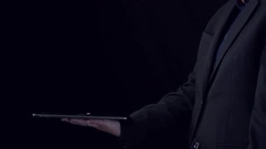 Bir iş adamı, modern teknoloji ve dijital yeniliği temsil eden HTML, Python ve Java gibi çeşitli programlama dillerini gösteren bir tablet bulundurur. Dörtgen