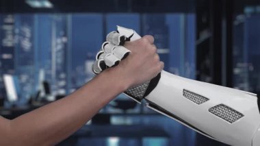 Bir dijital arayüz gelişmeleri gösterirken bir insan eli robotik bir eli sıkar. Bu video modern çalışma alanlarında insan ve makine arasındaki işbirliğini sembolize ediyor. Auvana
