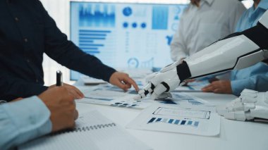 İnsanlar ve robotik teknolojiler arasındaki işbirliğini gösteren dinamik bir iş toplantısı, veri odaklı karar verme ve yenilikçi stratejilere odaklanıyor.