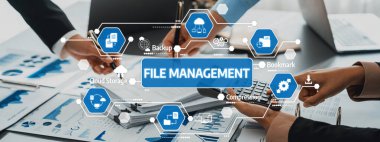 Modern bir ofis ortamında teknolojik araçlarla işbirliği içinde çalışan, dosya yönetiminde takım çalışması sergilenen dinamik bir sahne. Dostluk