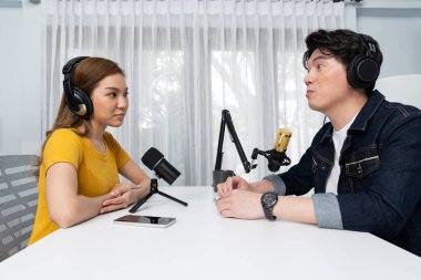 Gülümseyen radyo etkili sunucusu kulaklık takıyor kadın konuşmacı ile röportaj yapıyor sosyal medya internet sitesinden dinleyicilere bilgi paylaşıyor stüdyo kaydında sabah canlı yayın kanalı. İnfobahn.