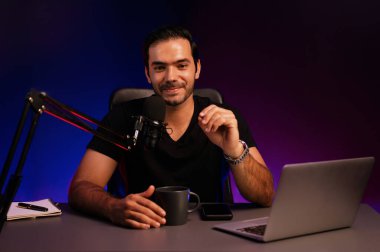 Yayıncı, fanclub dinleyicisiyle mikrofon kullanarak konuşuyor. Mor neon ışıklı modern stüdyoda yaratıcı olumlu düşünce konseptiyle canlı yayında finansal sorunları tartışıyor. Tahmin et..