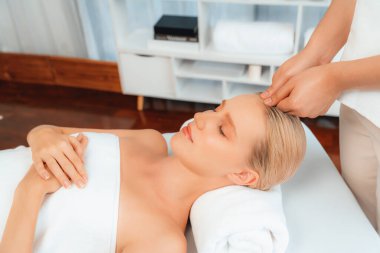 Kafkasyalı kadın stres önleyici kafa masajından ve lüks tatil beldesi ya da otel spa salonundaki modern ışık ortamında yüz güzelliği eğlencelerini şımartmaktan hoşlanıyor. Sessiz.