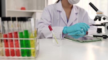 Laboratuvar kimya araştırmacısı mikroskop kullanarak yeni ilaç ya da tedavi geliştirir. Laboratuvar mikrobiyoloji ekipmanları ile bilimsel uzmanlık ile sağlık hizmetlerinin teknolojik gelişimi. Ağır çekim. Katı.