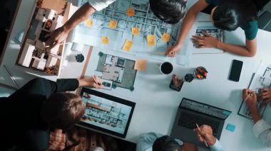 Üst düzey hava görüşlü iş adamları ev modeli ve dizüstü bilgisayarla iç mekan inşaatı hakkında beyin fırtınası yaparken mimar mühendisi de tasarım ve yazım işlerini planladı. Hizalama.