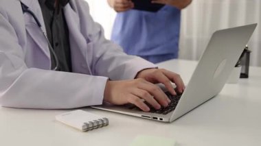 Hastane masasında birlikte çalışan ve tıbbi tedavi planlayan çeşitli profesyonel sağlık görevlileri. Takım çalışması başarılı hastalıklara ve hastalıklara yol açar. Ağır çekim. Katı.