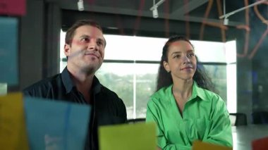 Yetenekli işadamı pazarlama fikrini cam duvardaki proje yöneticisine sundu. Yönetici projeyi yatırımcıya açıklıyor. Zeki iş adamları birlikte çalışıyor, beyin fırtınası yapıyorlar. Yönlendirici.