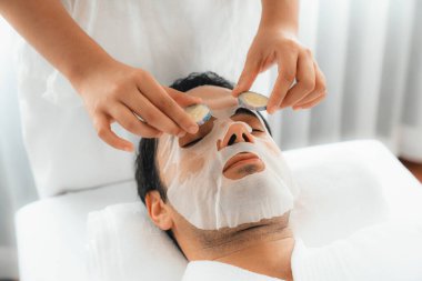 Kaplıca salonunun sakin atmosferi, insan müşterisi lüks salatalıklı yüz maskesi ile kendini yenileme zevkine kapılıyor. Yüz bakımı tedavisi ve güzellik konsepti. Sessiz.