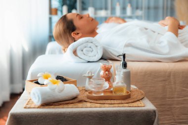 Aromaterapi masajı gündüz atmosferinde ya da spa salonunda bulanık bir kadına odak dekor ve spa aksesuarları kurarak tatil köyünde ya da otel arka planında keyifli aroma spa masajı yapan bir masaj. Sessiz.