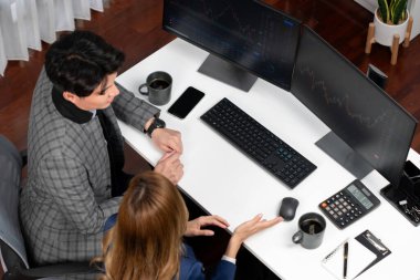 Başarılı Asyalı iş kadınının iş ortağı ile iş ortağı arasındaki dinamik borsa veri ekranına bakarak internet sitesi programını analiz etmenin en iyi görüntüsü. İnfobahn.