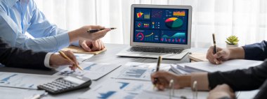 İş zekası ve veri analizi kavramı. Analizci ekibi laptop ekranında finansal veri analizi üzerinde çalışıyor. Etkili iş stratejik planlama için pazarlama göstergesi olarak. İçgörü