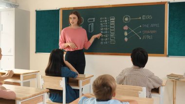 Zeki öğretmen sınıfta fikri açıklarken sevimli öğrenci ödevlerini kontrol ediyor. Not defterine bakıp matematik teorisinden çocuğa bahsederken sınıfta dolaşan çekici bir eğitmen. Pedagoji.