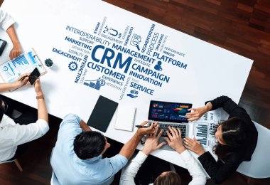 Ortak bir iş toplantısında CRM stratejileri ve pazarlama kampanyaları, modern ofis ortamında takım çalışması ve yenilikler ele alındı. Dostluk