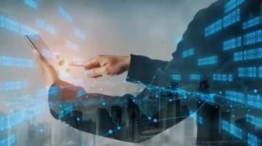 Bir iş adamı, dinamik bir şehir ortamında akıllı bir telefonla iletişim kurar. Dijital veri ve grafikler finans alanındaki teknoloji ve analizlere odaklandığını gösteriyor. Xenic