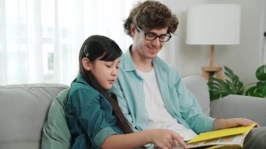 Beyaz bir baba ve tatlı bir kız kanepede otururken masal kitabı okuyorlar. Mutlu bir baba, sevimli bir Amerikan çocuğuna, birlikte zaman geçirirken hayal gücünün gelişmesi için hikaye anlatıyor. Pedagoji.