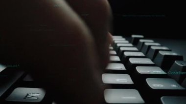 Dijital kodun ortasındaki bir klavyede el yazısının yakın plan görüntüsü, iş başında programlama ve teknoloji kavramlarına odaklanmış modern bir çalışma alanını gösteriyor. Xenic