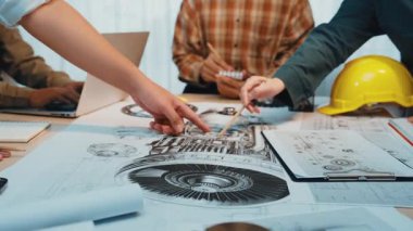 Bir grup mühendis ve tasarımcı modern ofis çalışma alanındaki teknik şemalar üzerinde aktif olarak işbirliği yaparak, yaratıcılığı ve yeniliği geliştirmek için araçlar ve teknoloji kullanıyorlar. SACTR