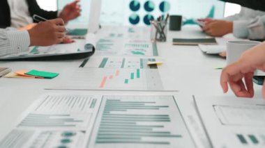 Renkli grafiklerin yer aldığı raporlara ilişkin iş verileriyle ilgilenen ellerin yakın çekimi, strateji ve analize odaklı profesyonel bir ofis ortamında işbirliğini vurgulamak. SACTR