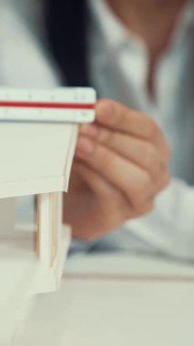 Profesyonel erkek mühendis ev modelini cetvel kullanarak ölçerken güzel bir kooperatif iş arkadaşı verileri analiz etmek için dizüstü bilgisayar kullanarak birlikte çalışıyor. Yaratıcı tasarım ve takım çalışması. - Yakın çekim. Tertemiz..