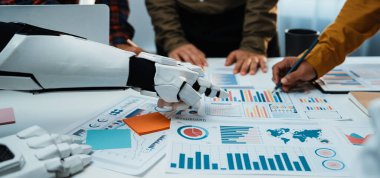 Robotik bir kol modern ofis ortamında profesyonellere yardımcı olurken, iş dünyası verilerini ve stratejilerini analiz ederken takım çalışmasını ve yeniliğini geliştirmektedir.