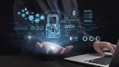 Bilgisayarın üzerinde dijital kilit sembolleri tutan, güvenlik, veri koruması ve yenilikçi teknoloji çözümleri temalarını vurgulayan kavramsal bir resim. Dörtgen