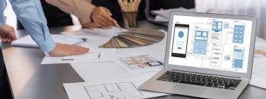 İç mimar tasarımcı grubu, daha kesin tasarım için planlar ve dizüstü bilgisayar ekran mimari yazılımı üzerinde birlikte tartışıyorlar. Modern ev tasarımı ve yenileme. İçgörü